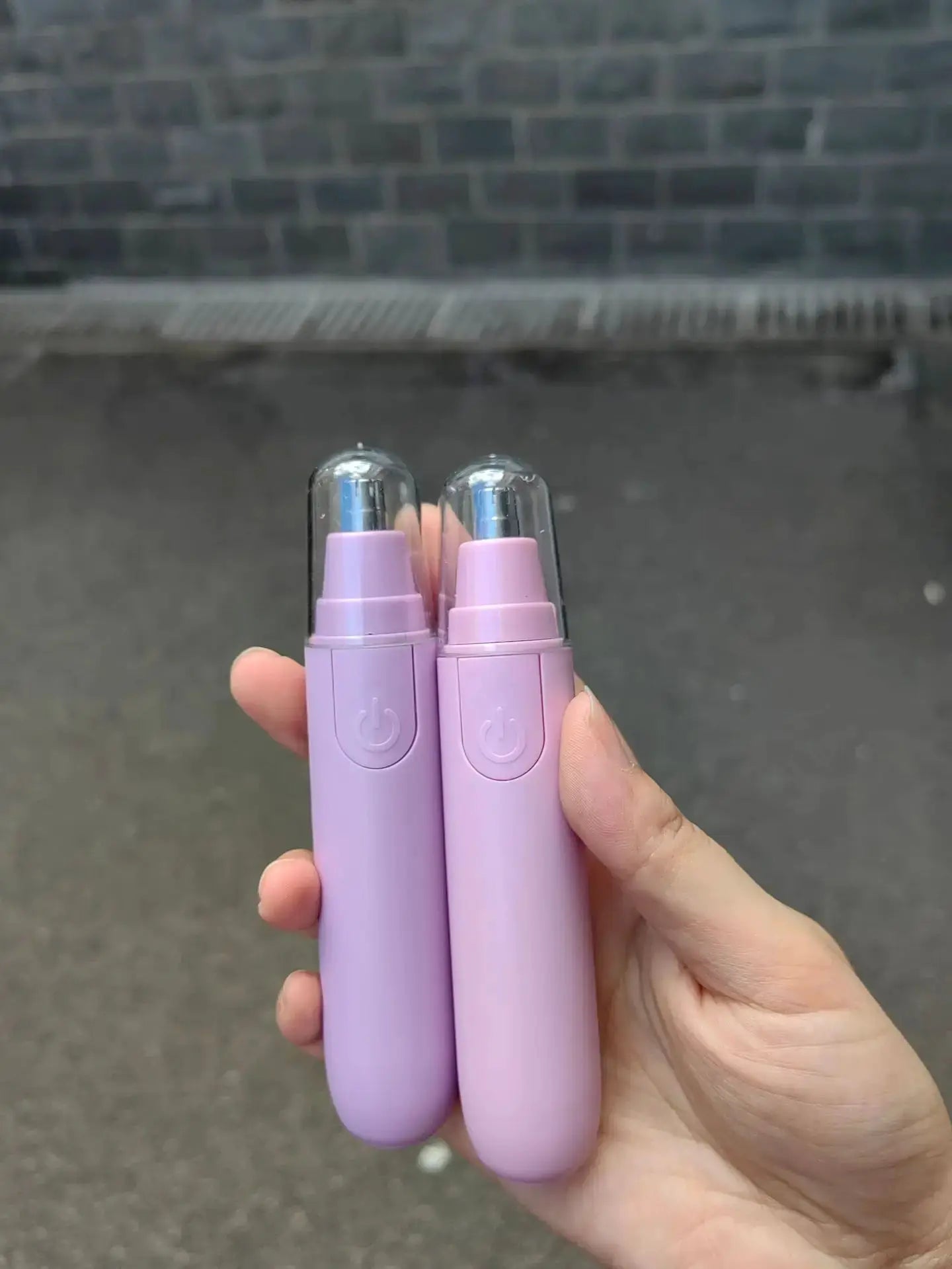 Electric nose hair trimmer dual-pack in lavender purple with clear caps.