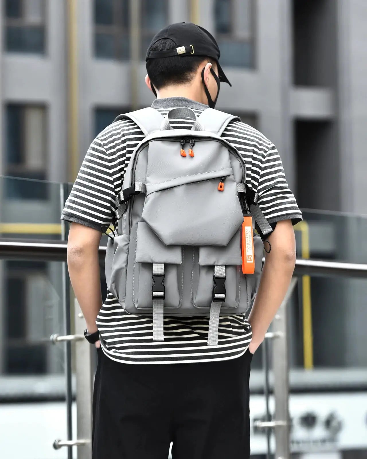 Grey luxury men's backpack with 15.6-inch laptop compartment and multiple pockets, orange zipper pulls