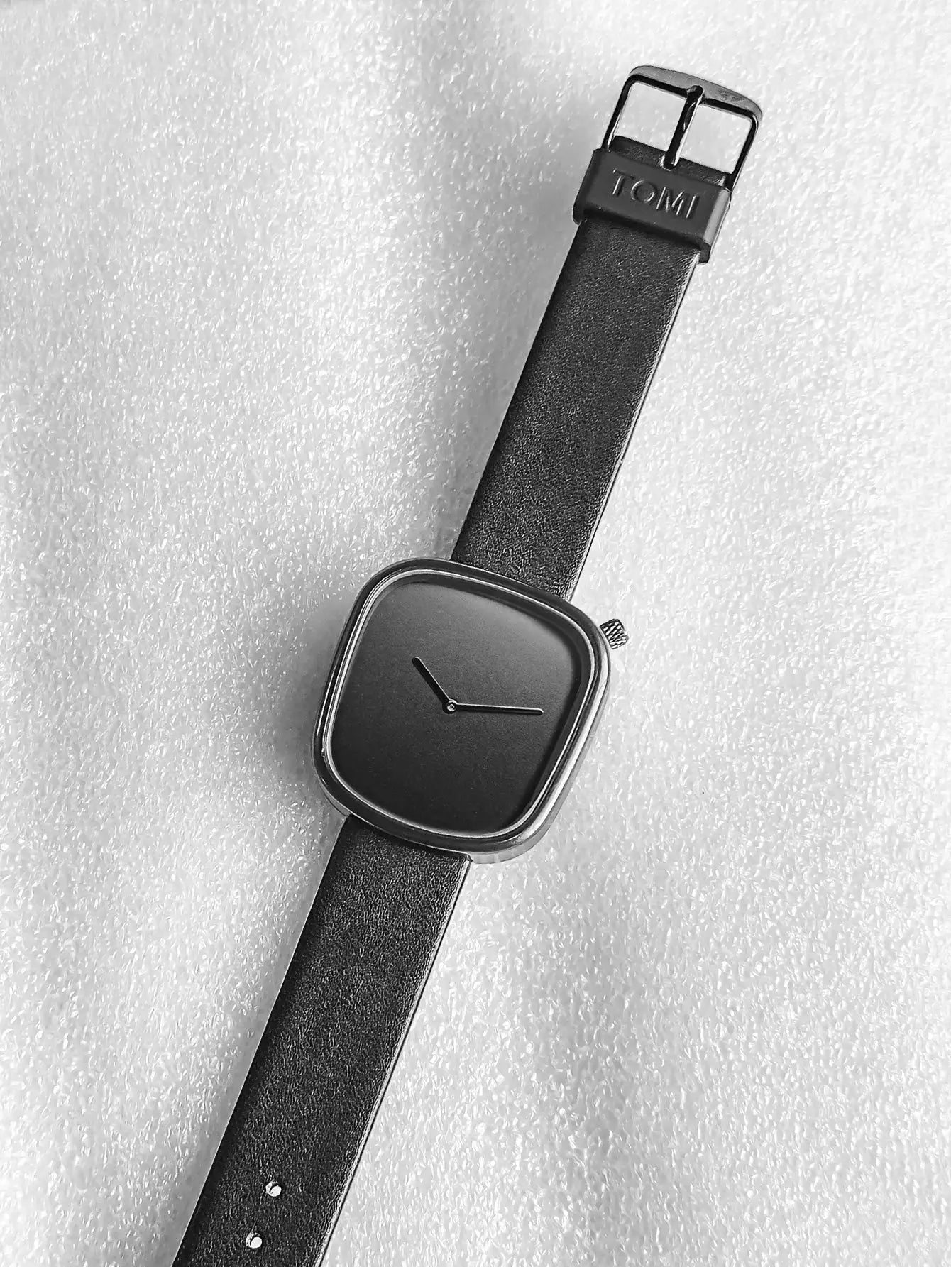 TOMI square minimalist watch with black leather strap and black dial.
