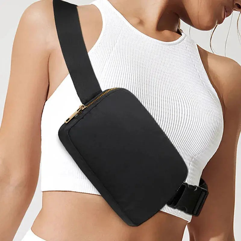 Black waist bag with gold zipper, worn crossbody across the chest