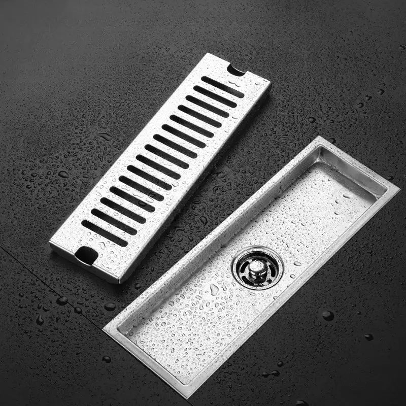 Long rectangular stainless steel floor drain (304) by Simples Market with slotted grate.