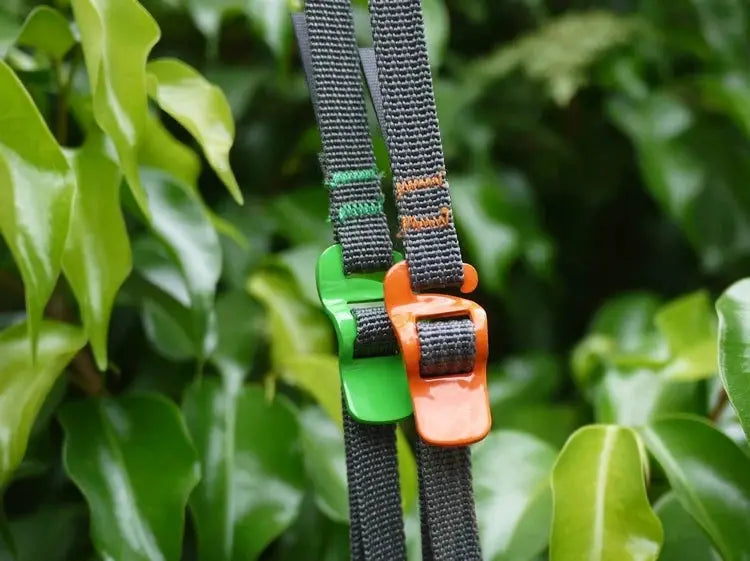 Luggage strap set by Simples Market; two black webbing straps with green and orange quick-release buckles