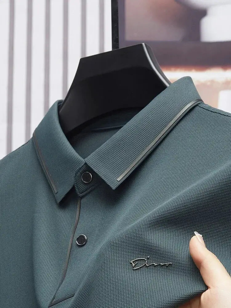Men's polo shirt in teal textured fabric with polo collar and button placket; small chest embroidery.