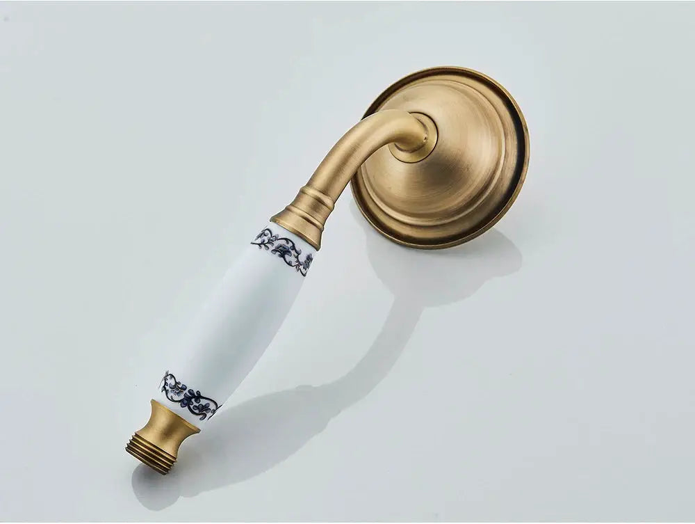 Antique brass handshower with ceramic white handle and blue detailing on brass wall plate, Simples Market