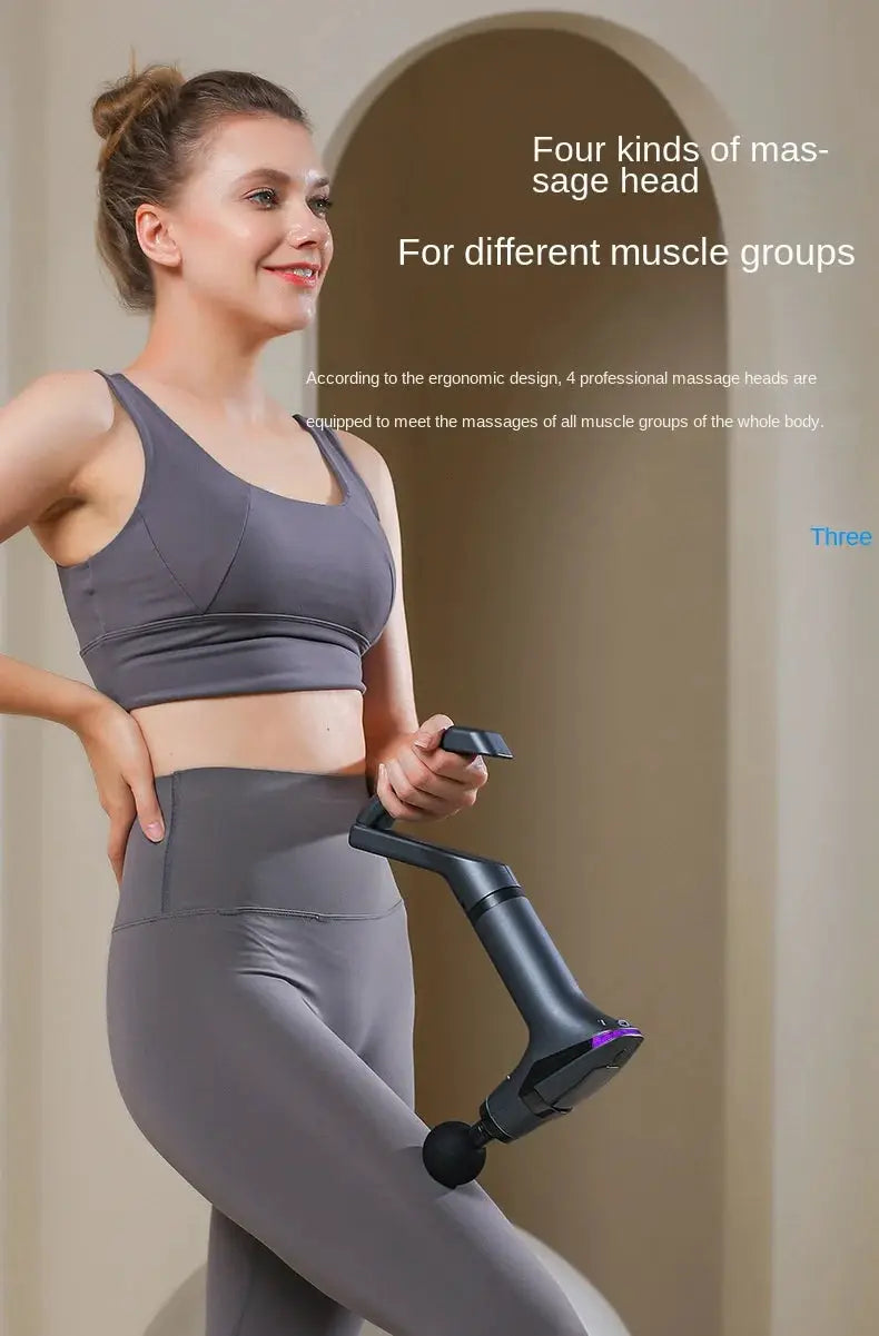 Long-handle electric massage gun with multiple head attachments held by a woman in gray activewear