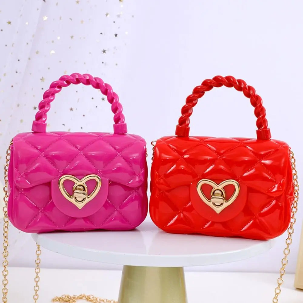 Kids PU leather crossbody bags by Simples Market in pink and red with heart buckle and braided handles (2 bags).