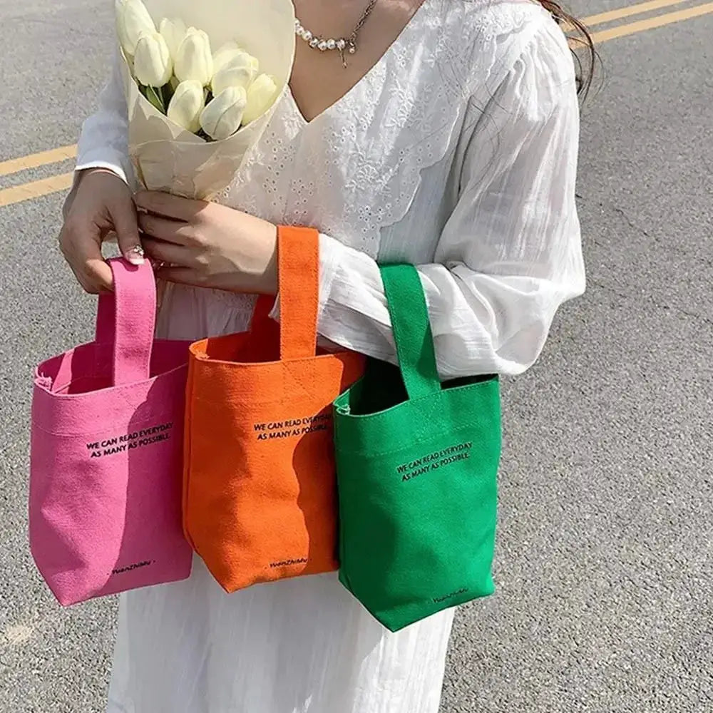 Simples Market canvas tote bags; set of three in pink, orange, and green with short handles.