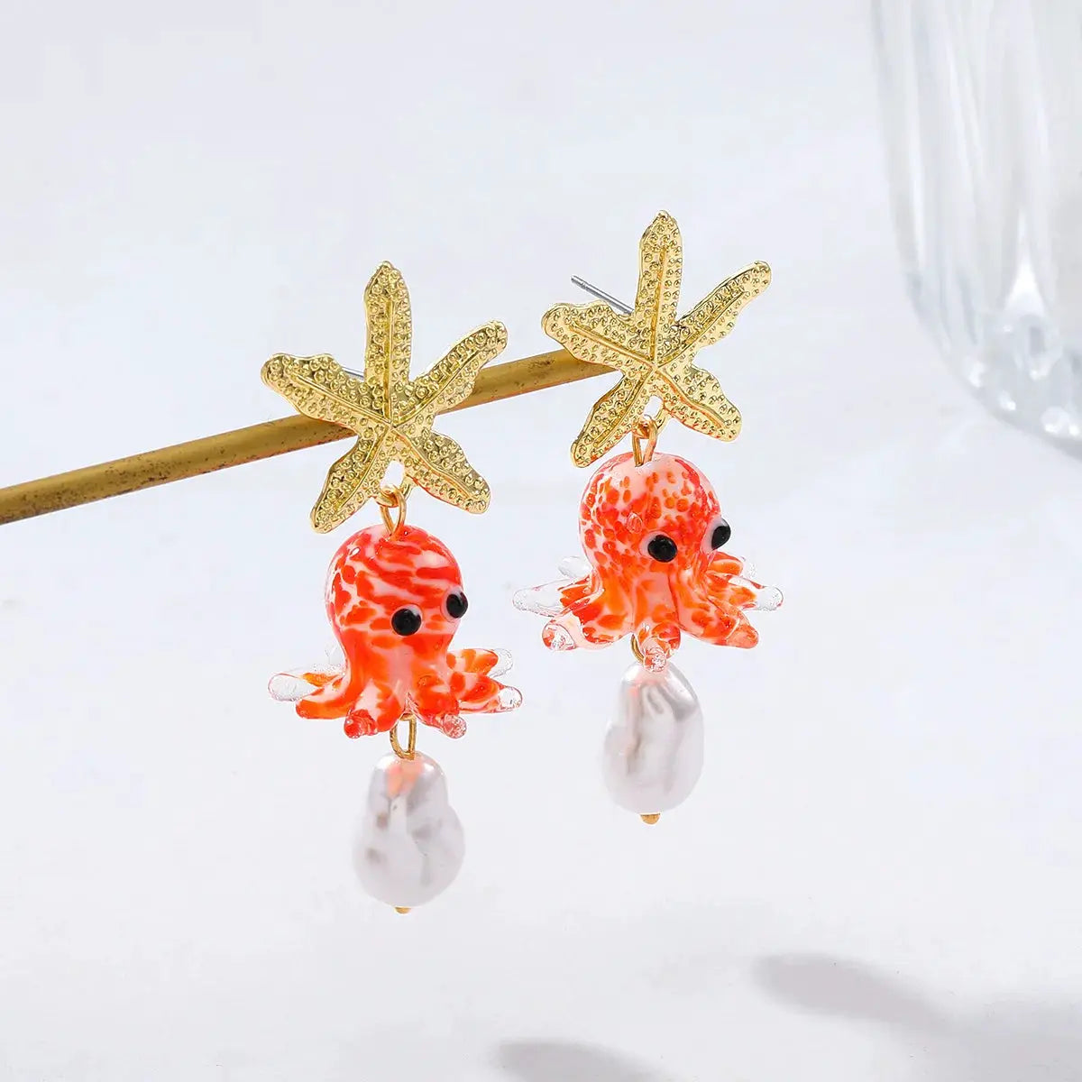 Cute octopus earrings by Simples Market with gold starfish studs, orange glass octopuses and white pearl drops