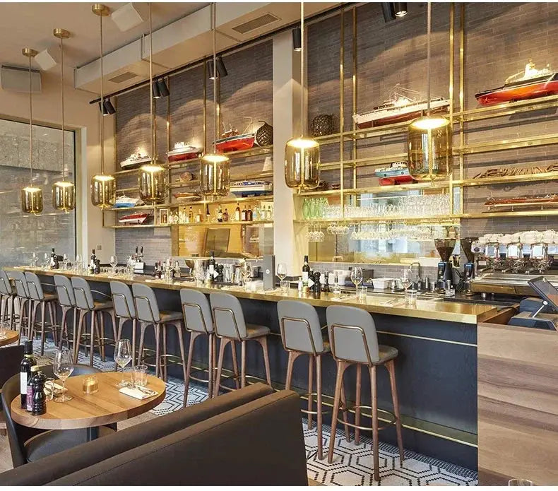 Simples Market minimalist pendant lamps over a cafe bar; brass frames with clear glass shades, several fixtures