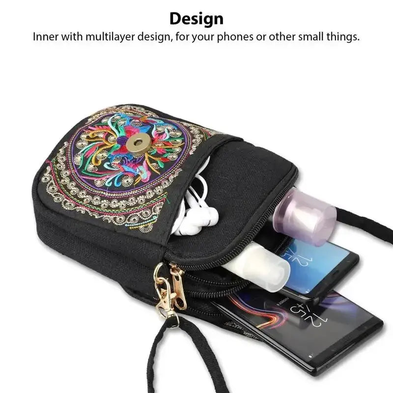 Embroidered crossbody phone bag, black canvas with colorful floral embroidery and a zipper pocket.