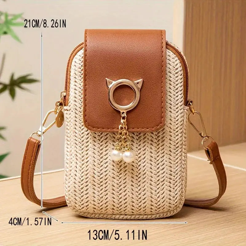 Simples Market mini crossbody bag with woven straw body and brown leather flap, gold ring clasp and pearl tassel