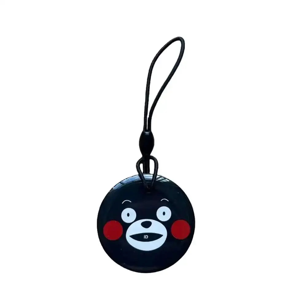 Round black RFID key tag with cartoon bear face and attached strap.