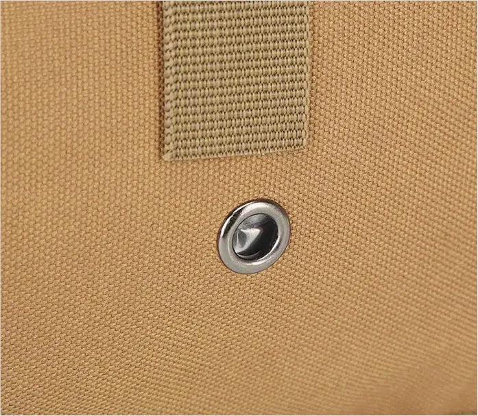 Tactical sling bag in tan canvas with metal grommet and webbing loop.