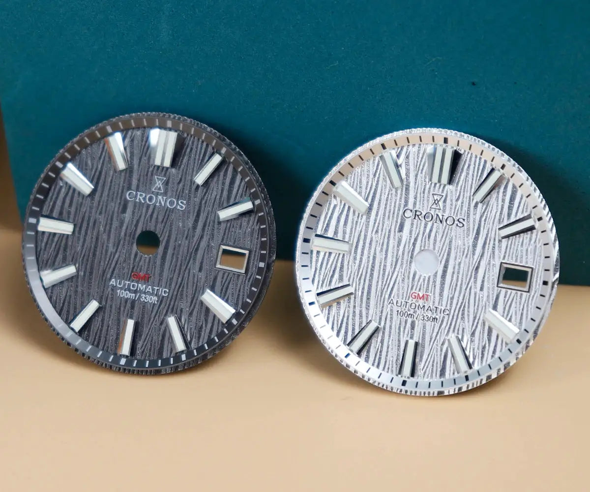 2 Cronos GS watch dials with birch-pattern texture, dark and silver finishes, GMT automatic, 100m