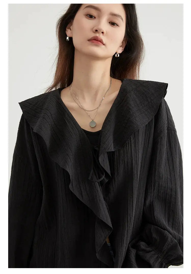 Women's black loose blouse with large ruffled collar, long sleeves and textured fabric