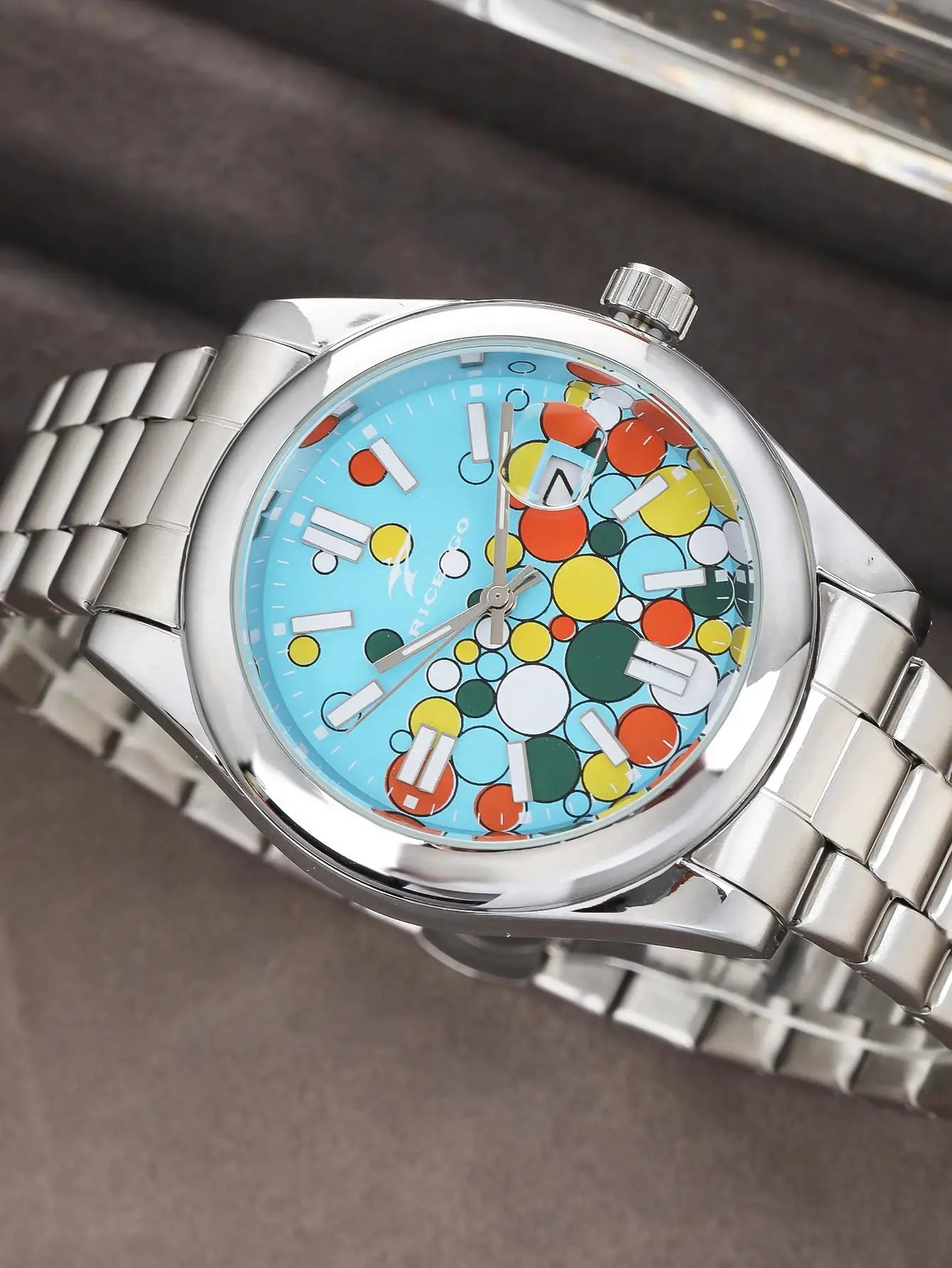 Classic men's quartz wristwatch with stainless steel band, blue dial featuring colorful circle pattern and date