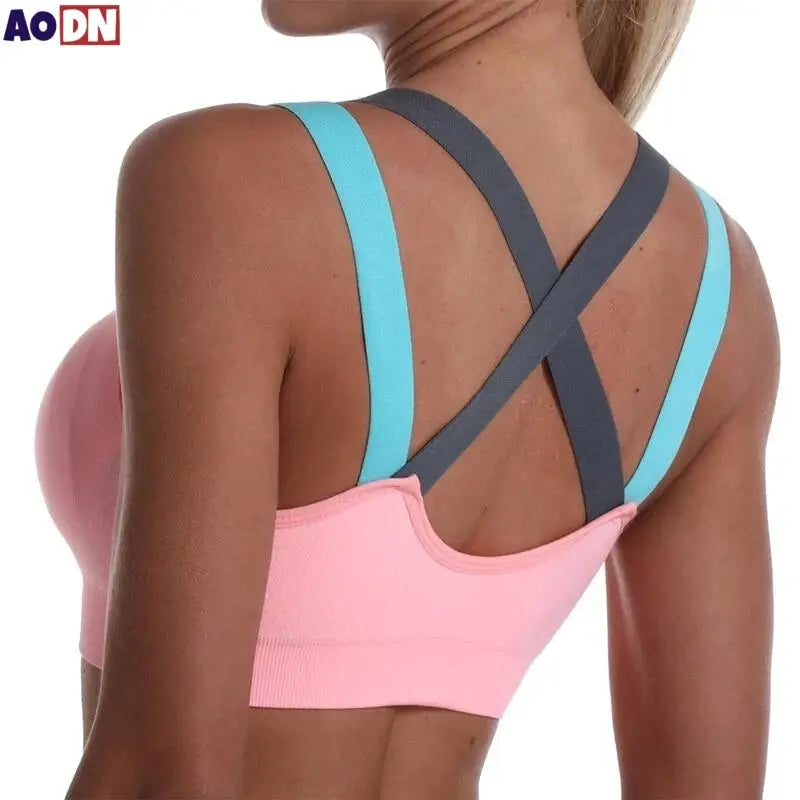 Color-blocked cross-back sports bra in pink with turquoise straps and gray crisscross back, back view
