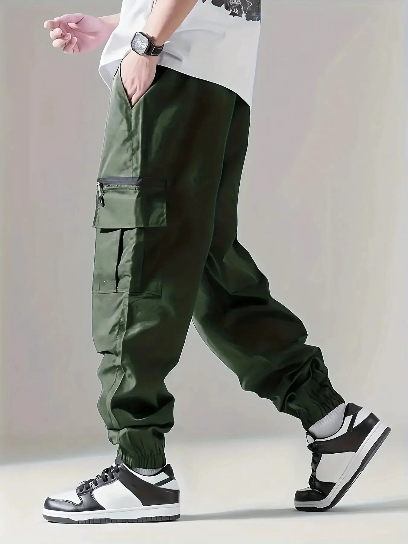 Men's cargo pants in olive green with multiple pockets, including a zippered side pocket, and elastic cuffs