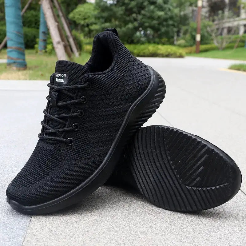 Pair of men's black knit sneakers, breathable lightweight walking shoes with ridged outsole