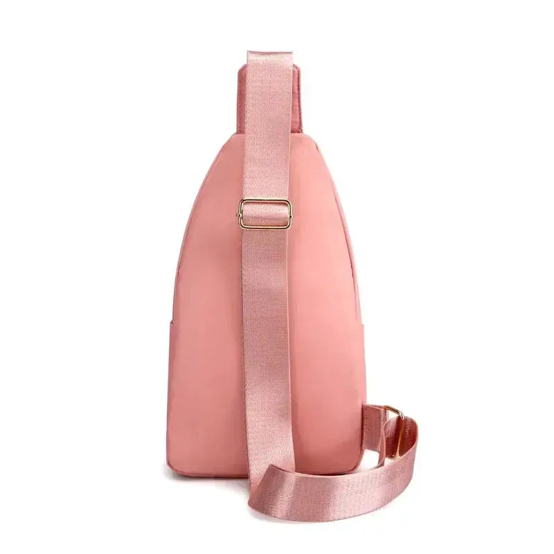 Shoulder bag by Simples Market in pink with wide strap and gold buckle, composite fabric