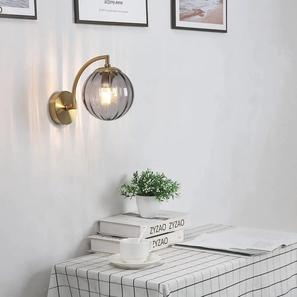 Simples Market modern LED wall lamp with glass globe shade and brass curved arm, wall-mounted