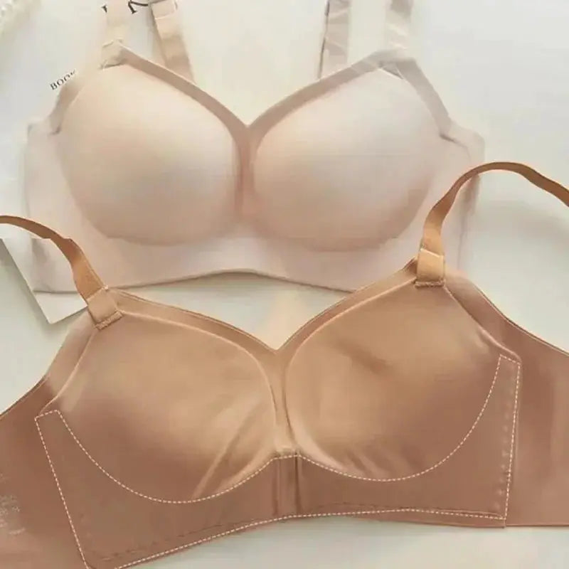 Two nude-toned bras with molded cups and wide underbands in light beige and tan.