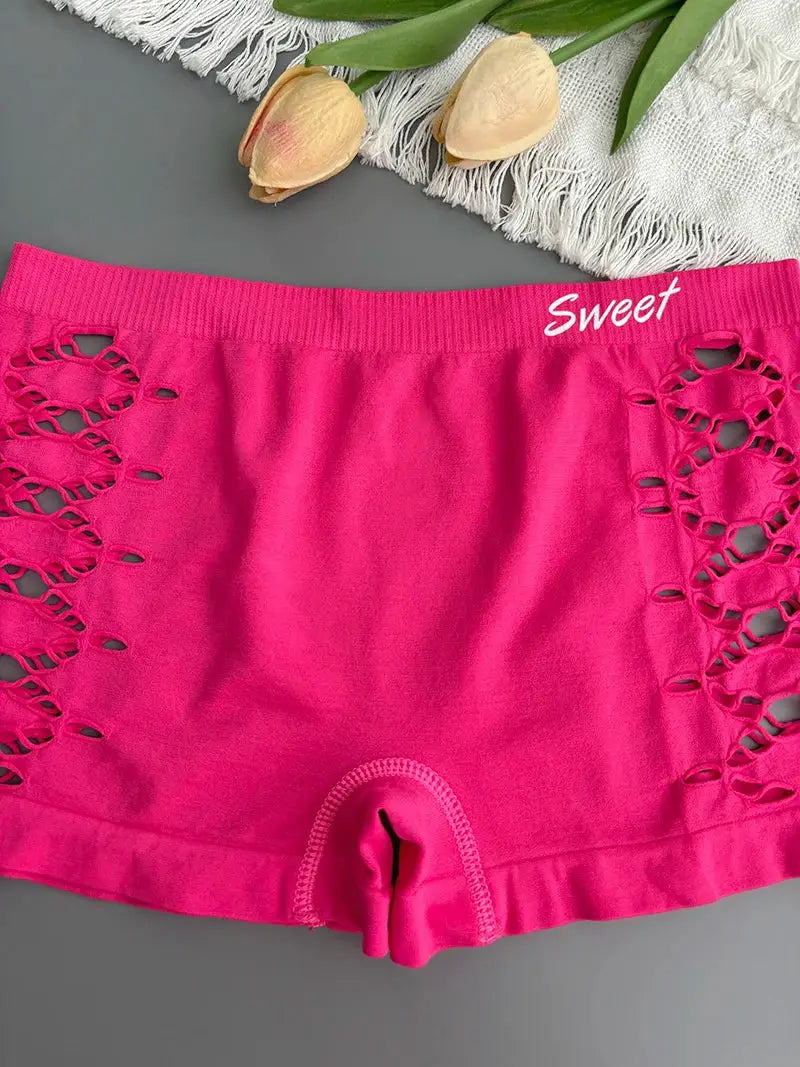 Pink seamless shorts with side lattice cutouts and a branded waistband reading Sweet