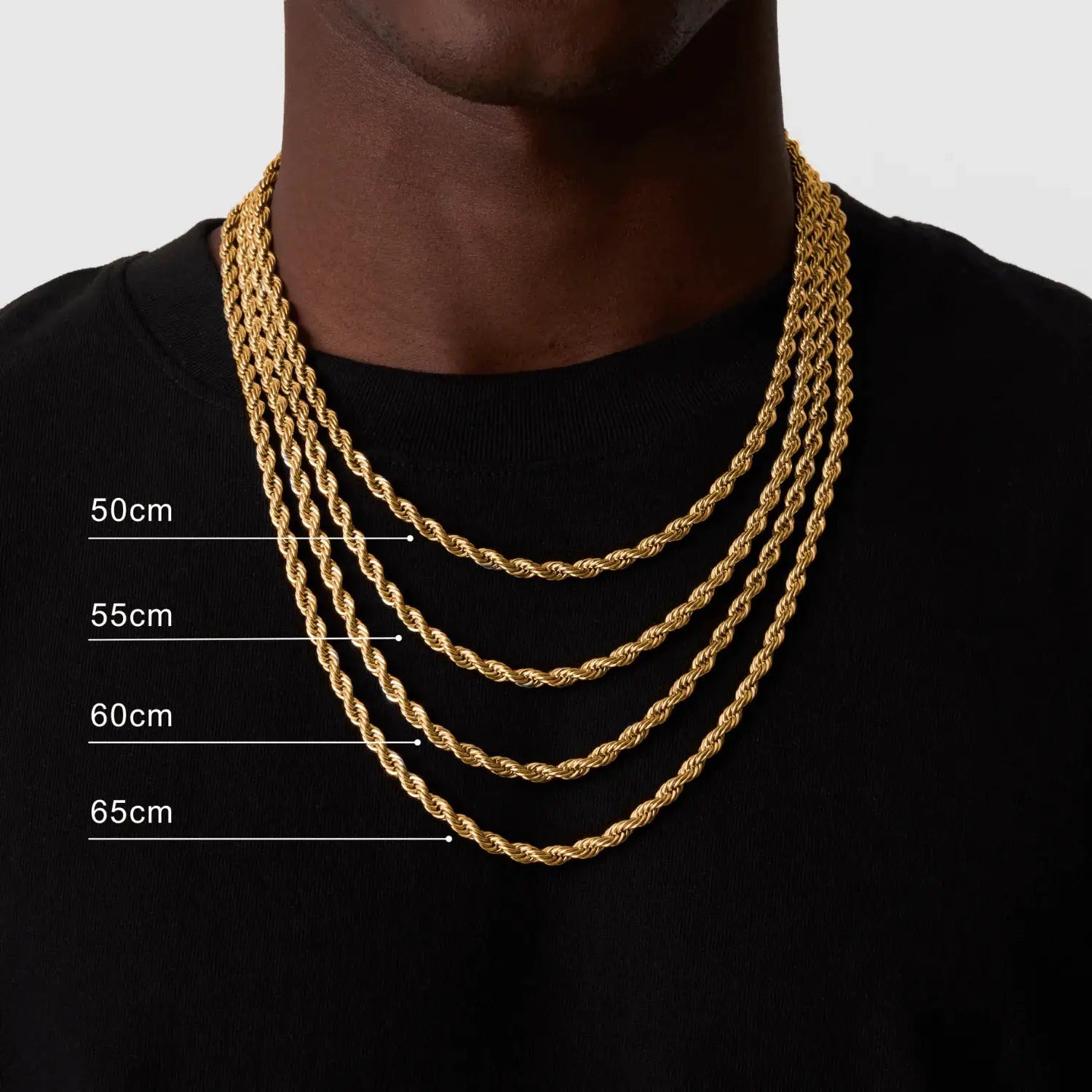 Gold-tone rope chain necklace set with four layered twist chains in 50–65 cm lengths on a black shirt