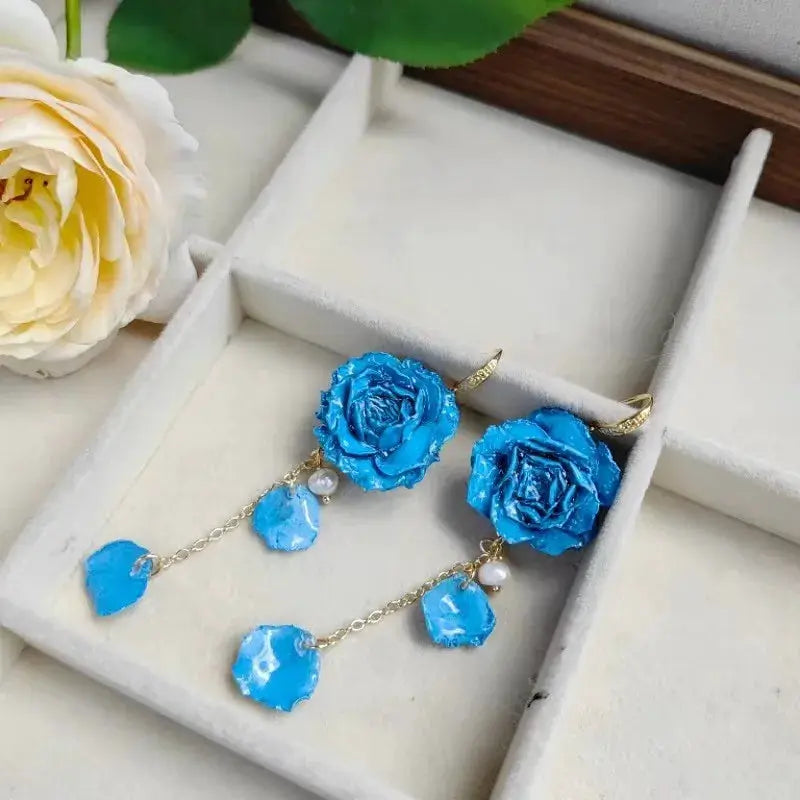 Pair of blue rose long earrings with epoxy resin petals, gold chains and dangling stones