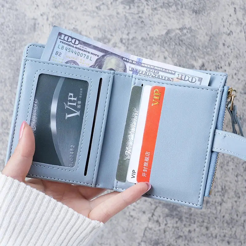 Mini crocodile-print clutch wallet in light blue with card slots and a zippered coin purse