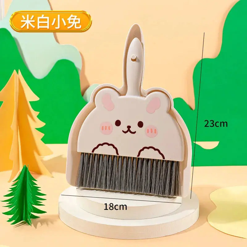 Mini cartoon bunny-shaped desktop cleaning broom with cream body, gray bristles, and white round stand.
