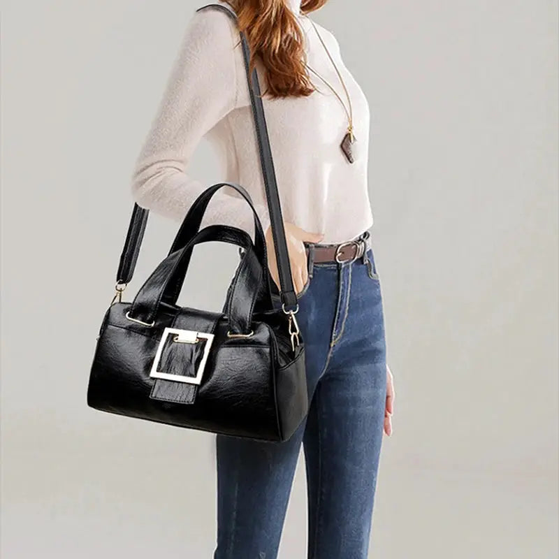 Women black leather top-handle bag with gold square buckle and long shoulder strap