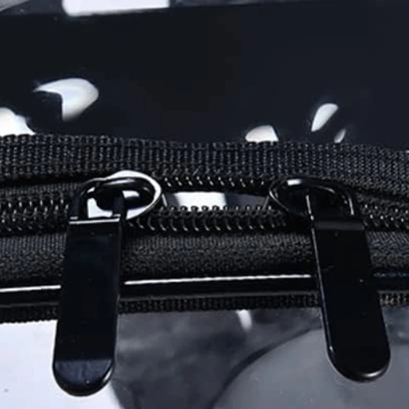 Clear backpack with black dual zipper pulls on transparent plastic.