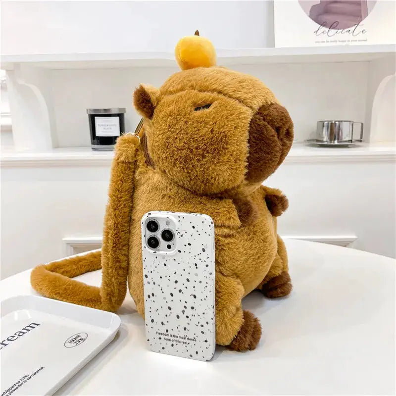 Capybara plush backpack, brown fuzzy with a small yellow fruit on top, crossbody bag.