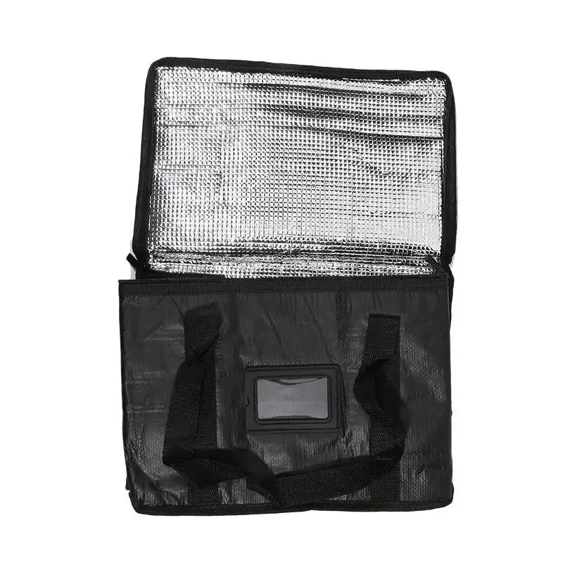 Portable black insulated food delivery bag with reflective foil lining, front label window and dual carrying handles.
