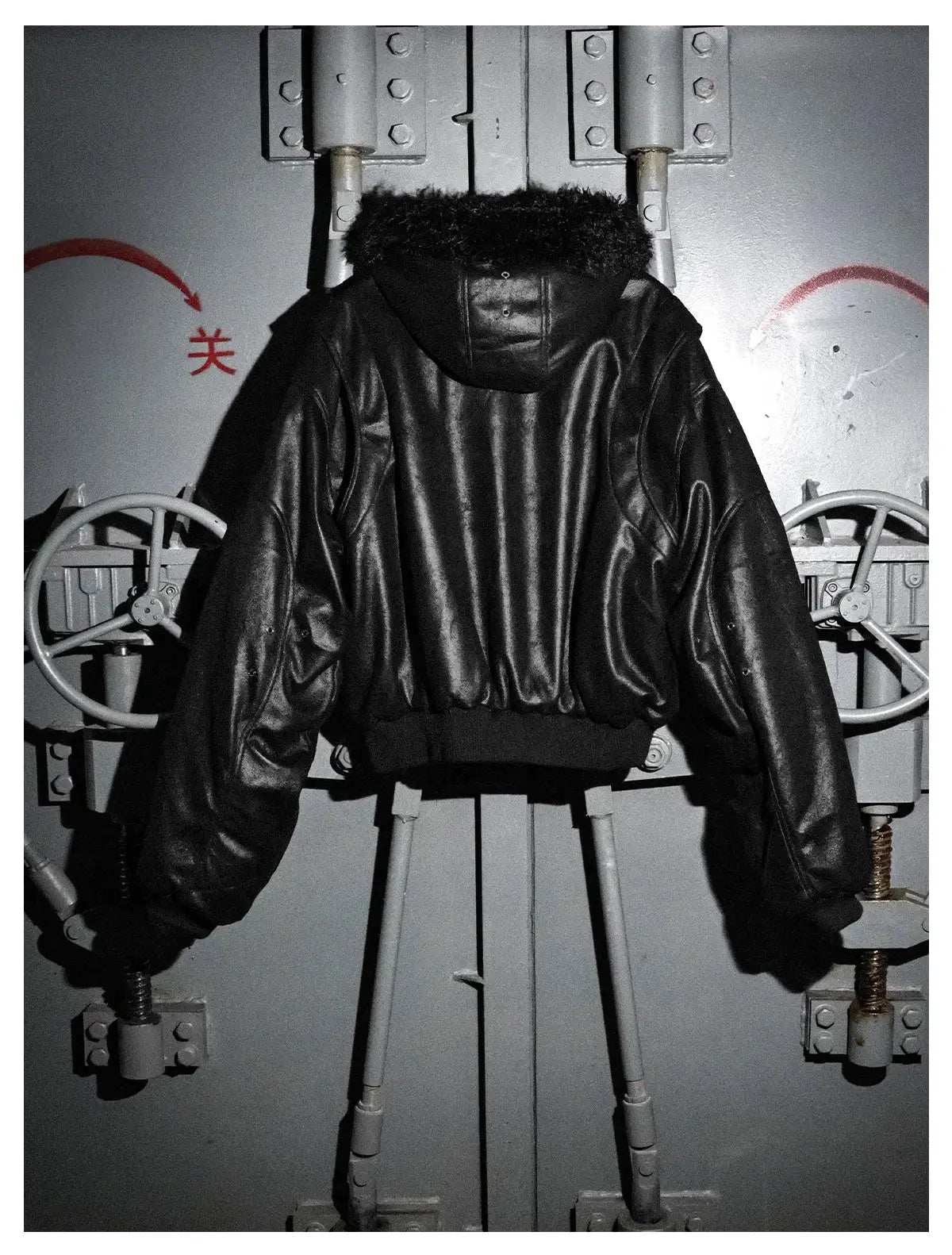Black PU leather men's jacket with a short oversized cut and faux fur-trimmed hood