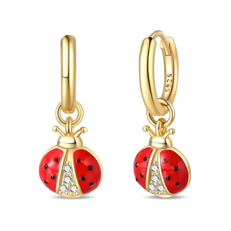Pair of gold-tone hoop earrings with red ladybug charms and crystal accents
