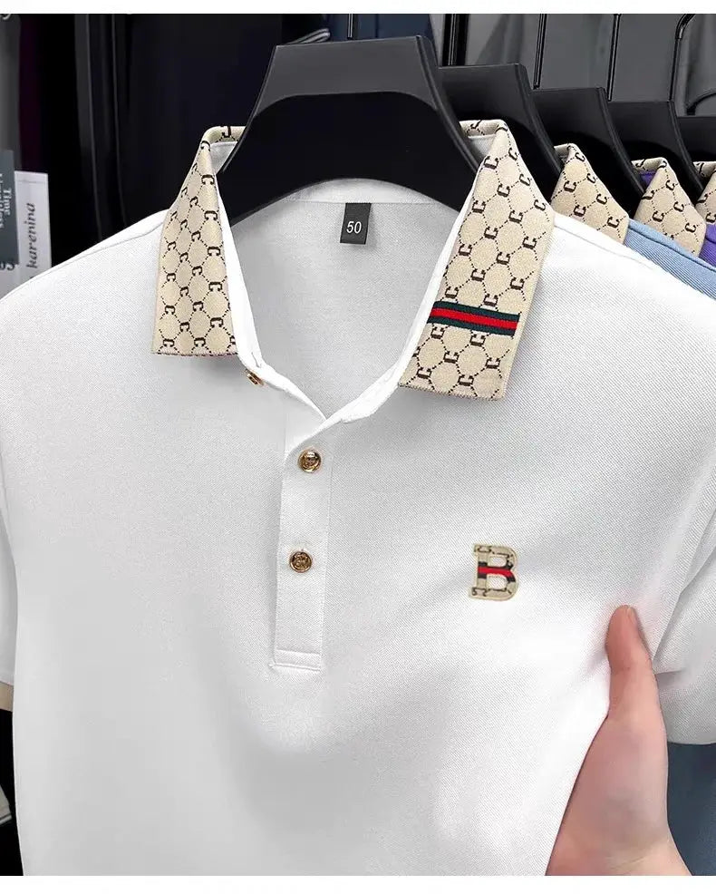 Simples Market white short-sleeve polo with beige monogram collar, color-blocked lapel, and gold-tone B emblem.