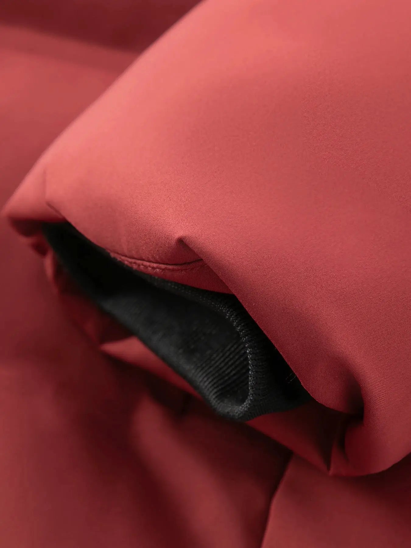 Men's red cotton jacket with black interior trim, close-up fabric detail