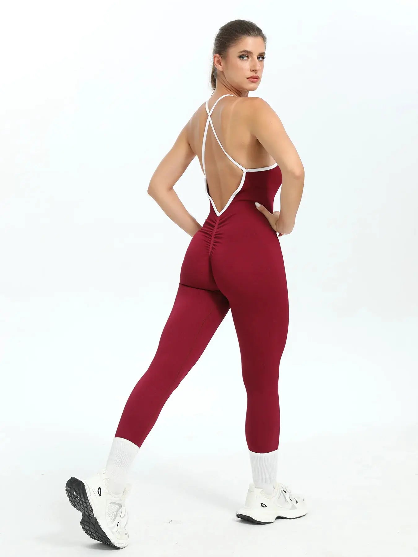 Women seamless sports jumpsuit in burgundy with white cross-back straps and open-back design