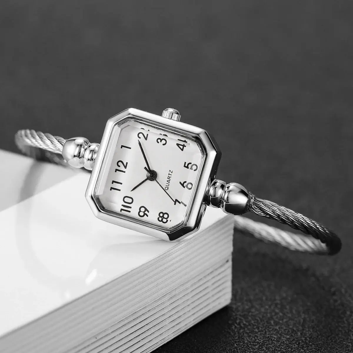 Women's square Roma dial quartz watch with a silver bracelet strap and twisted cable band.