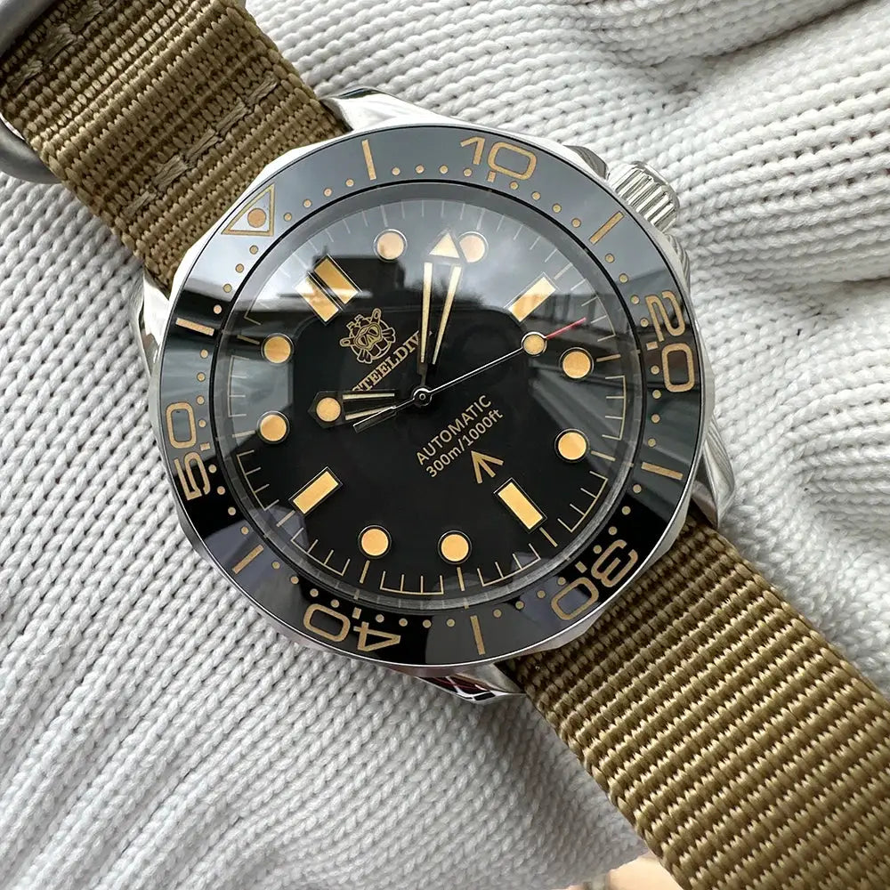 STEELDIVE SD1957 automatic diver watch; black dial with gold lume markers, ceramic bezel, 42mm case, khaki strap
