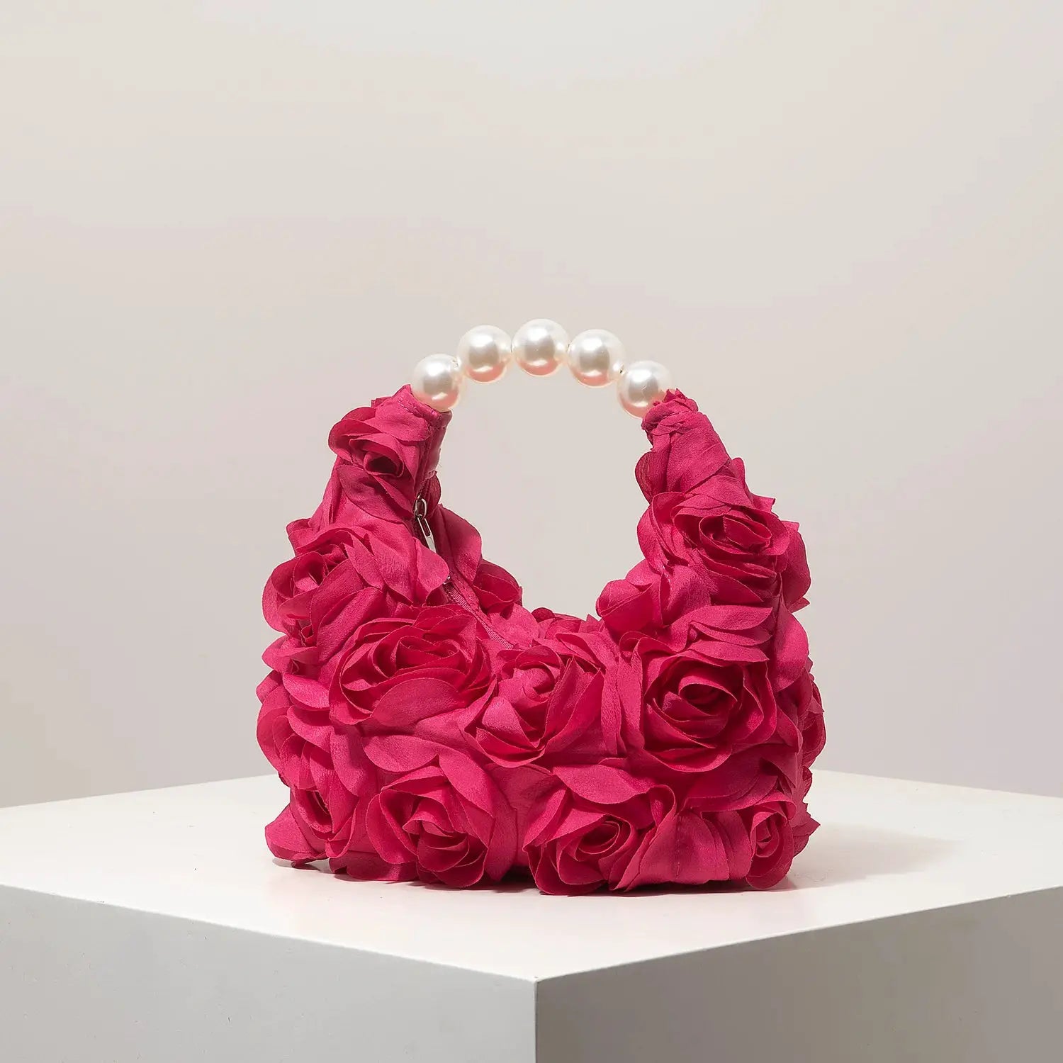 Bolso de mujer rosa con flores de tela y asa de perlas blancas