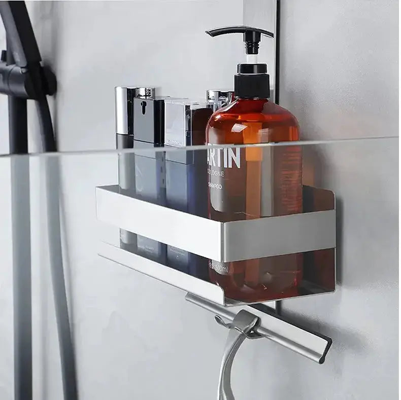 Movable bathroom shelf organizer by Simples Market; silver metal shelf mounted on a glass shower panel with toiletries