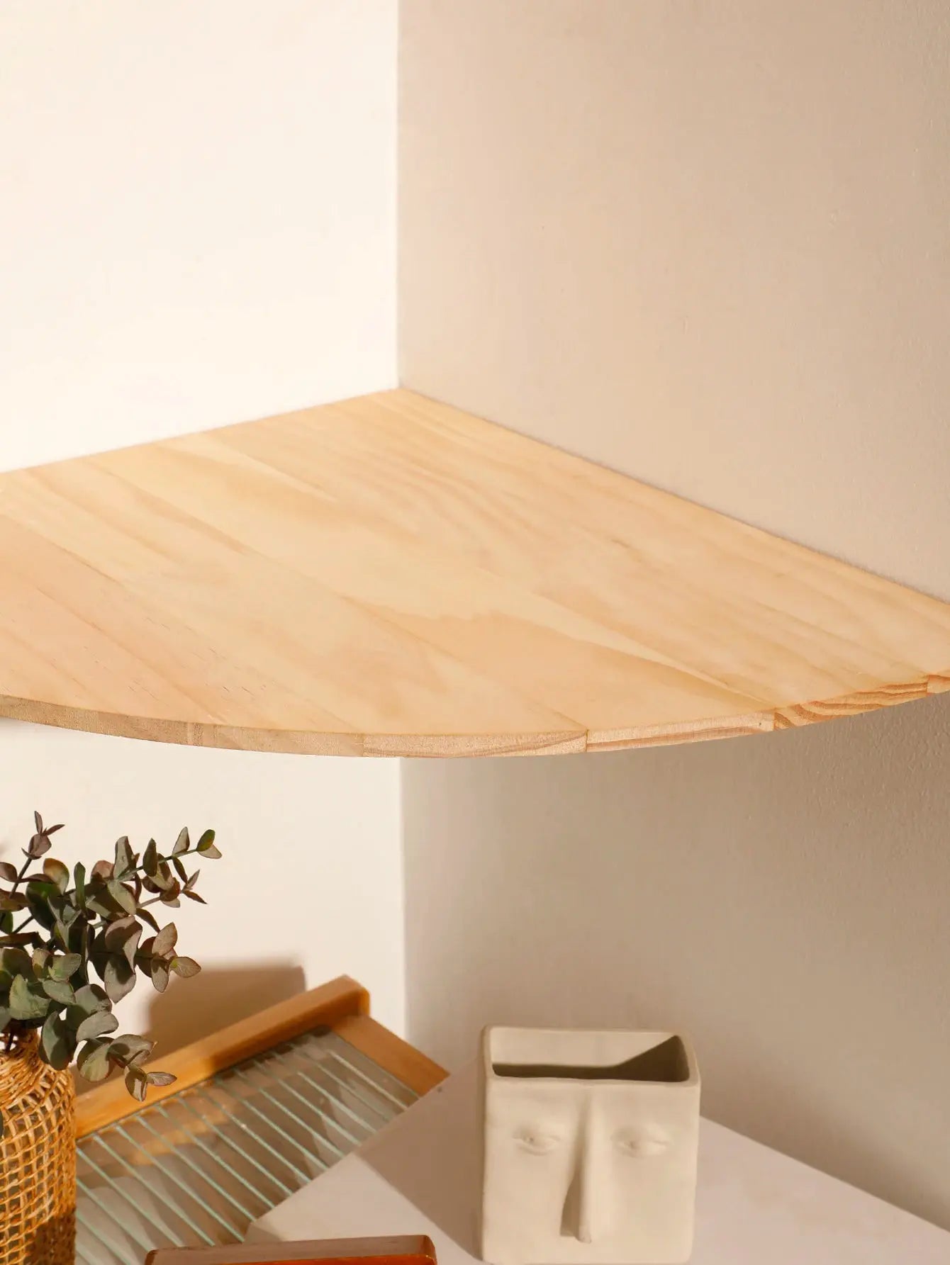 Floating wall corner shelf in light natural wood with rounded end, ideal for bedroom, living room, or kitchen