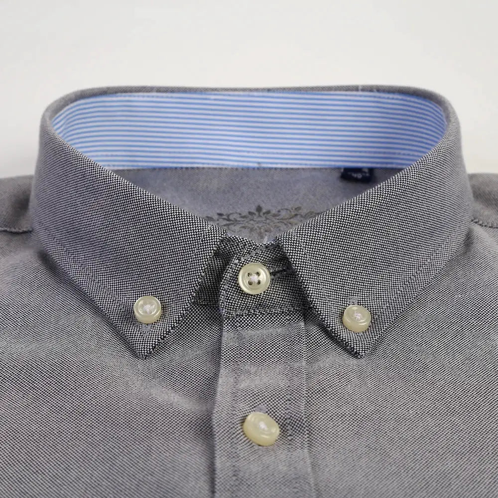 Men's grey micro-textured oxford shirt with button-down collar and blue striped inner collar.