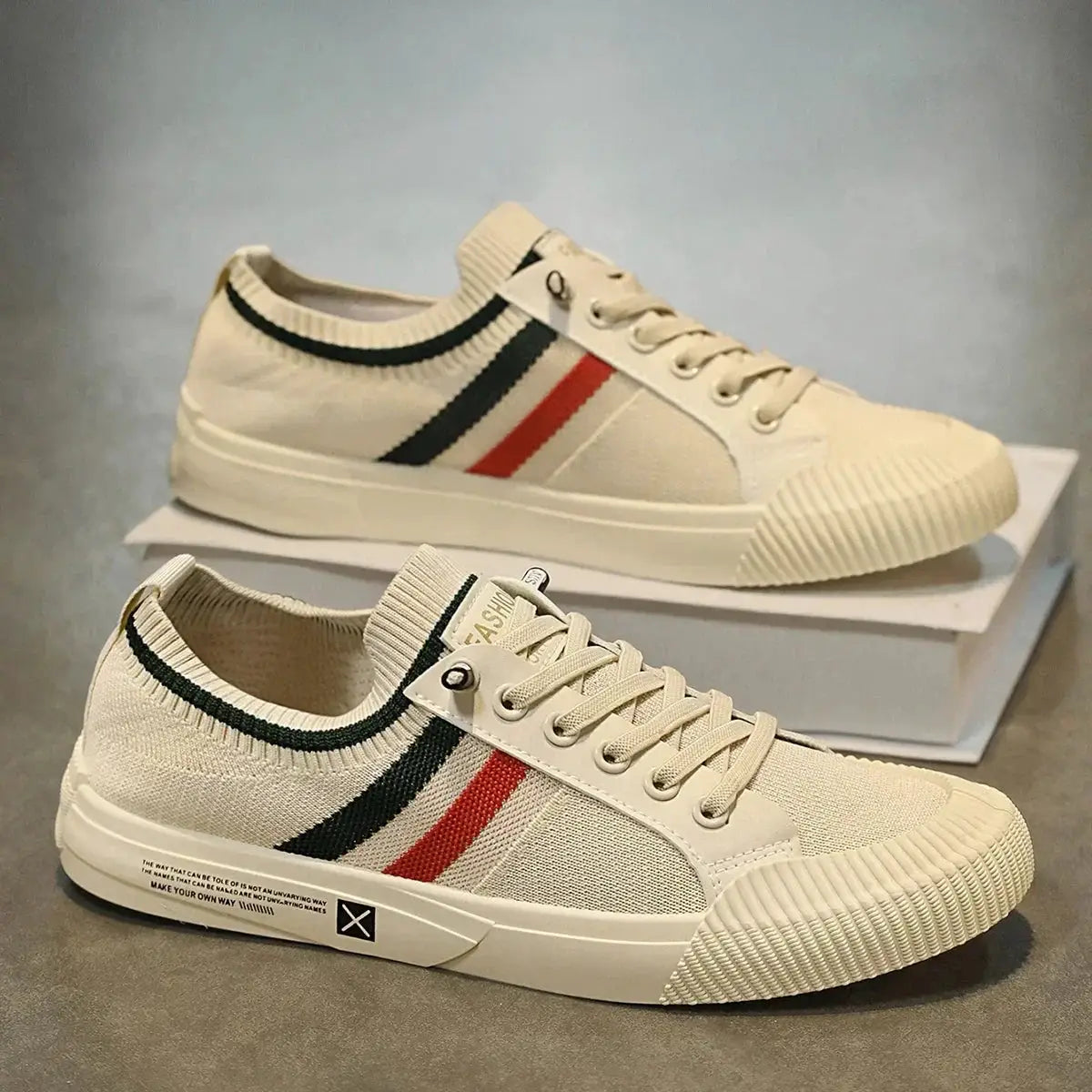 Men's cream canvas sneakers with black and red side stripes, rubber toe caps, two shown