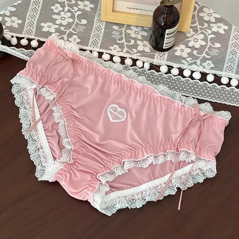 Plus-size pink lace panties by Simples Market with heart embroidery and white lace trim