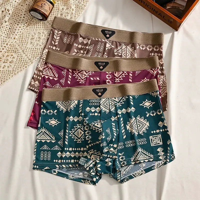 3-pack men's boxer shorts in ice-silk fabric with geometric tribal prints (teal, burgundy, beige) and elastic waist.