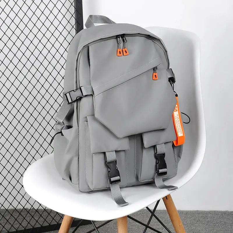 Simples Market luxury gray men's backpack with a 15.6-inch laptop compartment and orange zipper pulls.